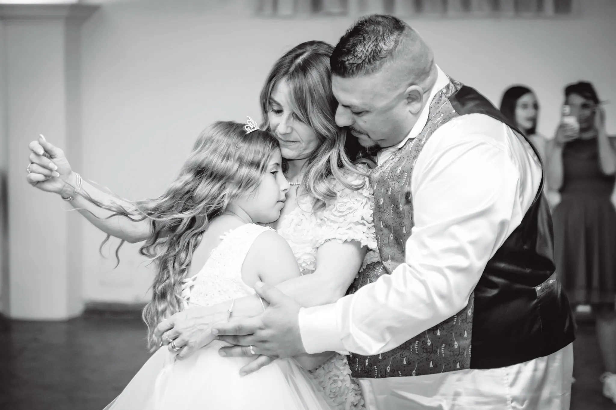 Ballo in bianco e nero: la bambina della comunione stretta tra due adulti