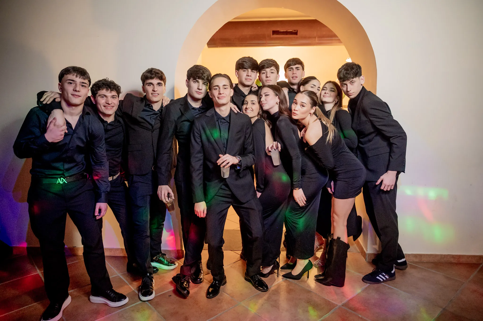 Foto di gruppo scatenata degli amici in pista sotto le luci della discoteca