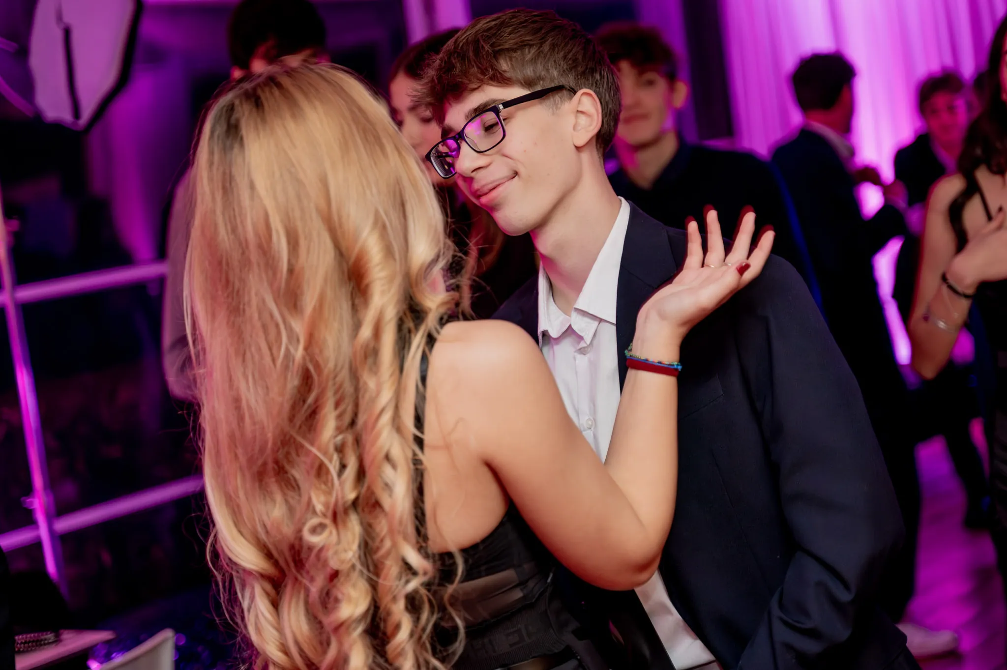 Un ragazzo e una ragazza ballano tra le luci viola