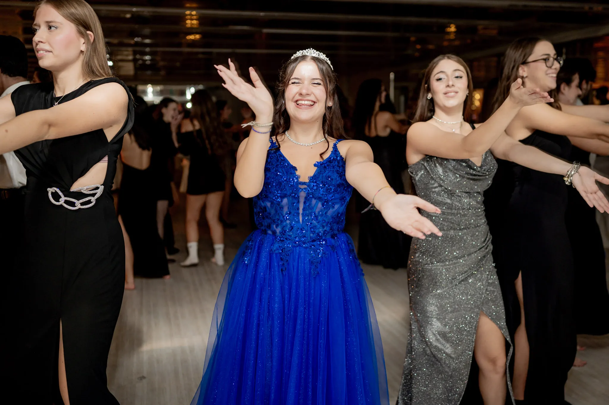 La festeggiata in abito blu balla in pista con le amiche