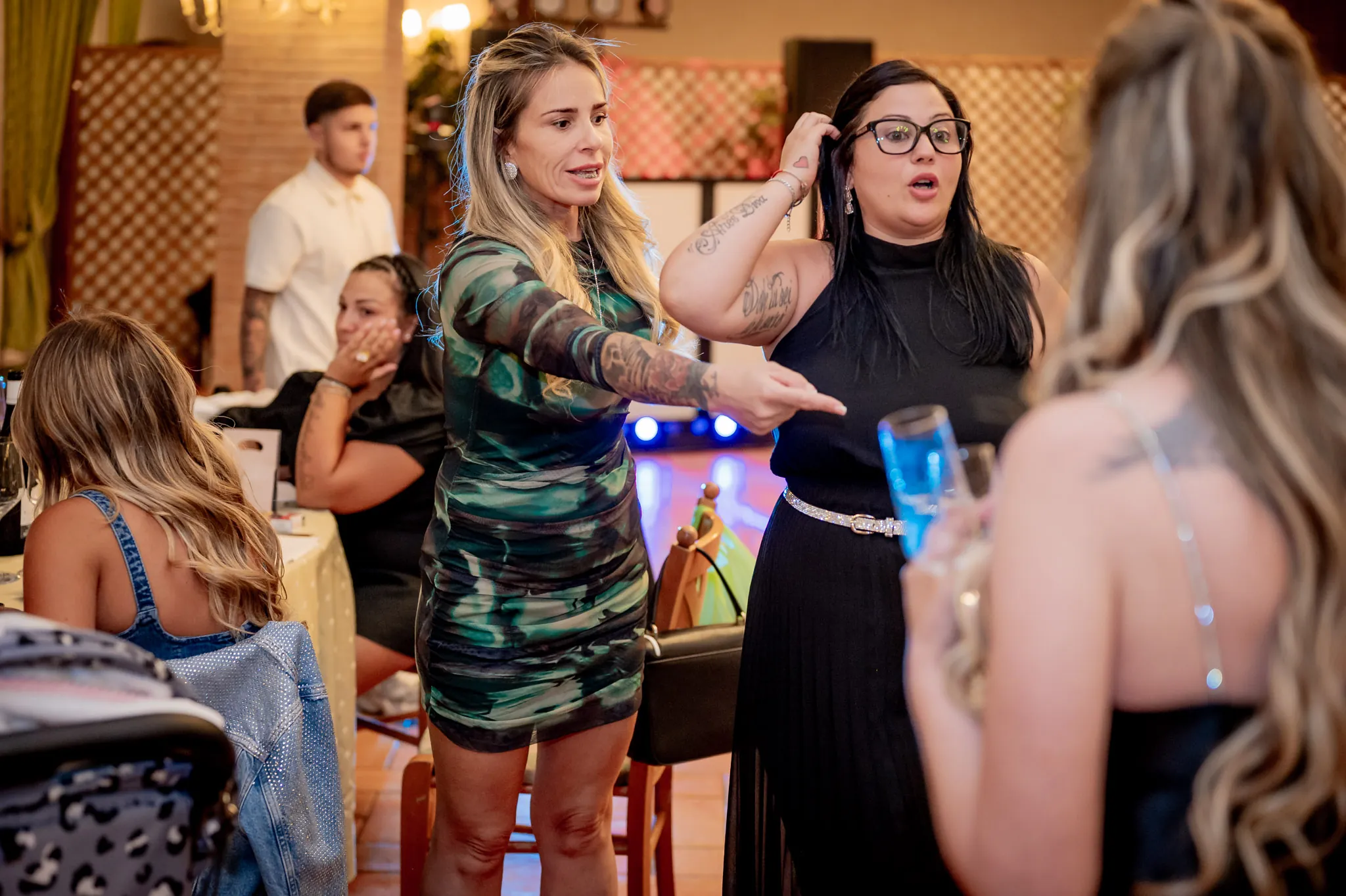 Invitate che ridono e indicano qualcosa durante una serata in sala