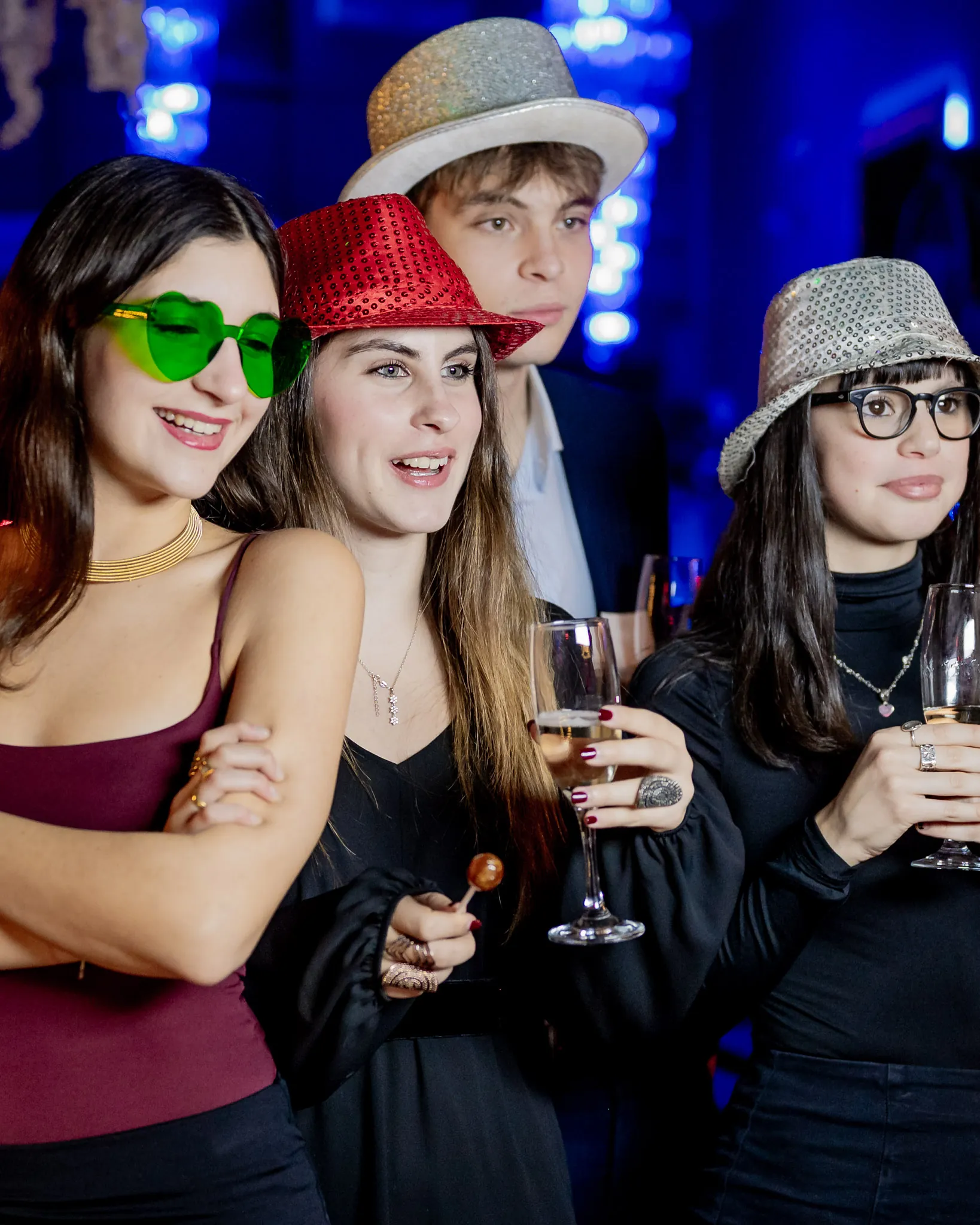 Ragazzi con cappelli e occhiali buffi in posa per lo scatto al photobooth