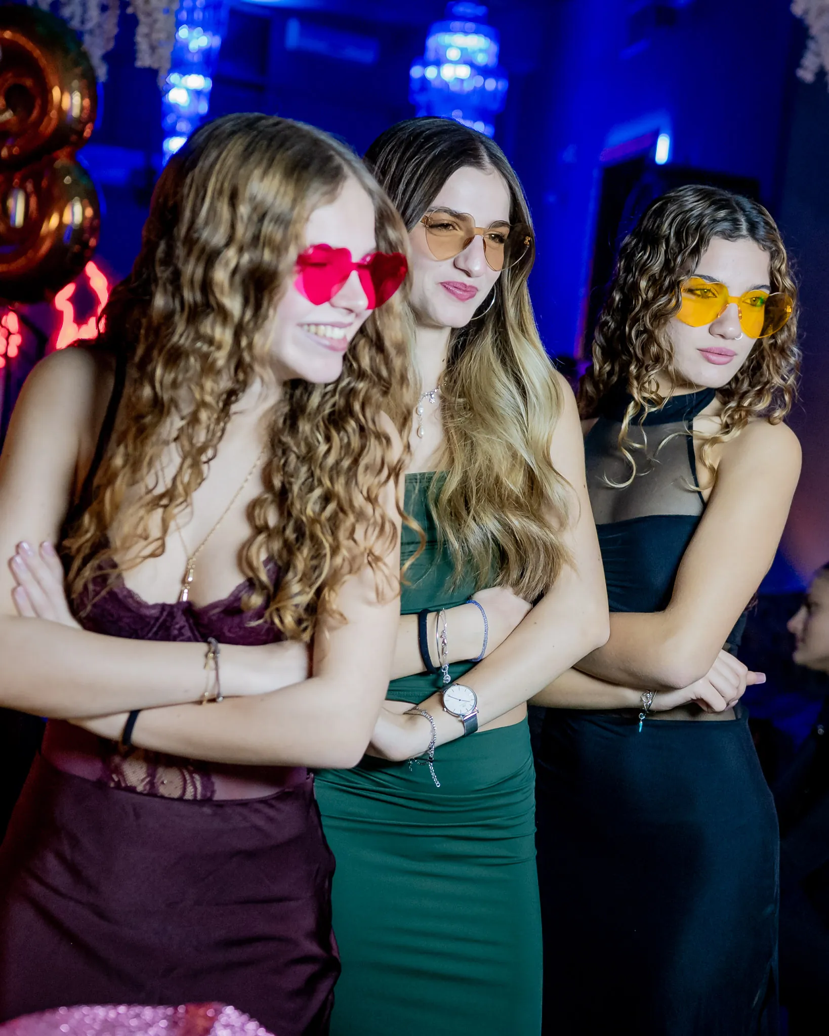Tre ragazze con gli occhiali a cuore davanti alla postazione delle foto