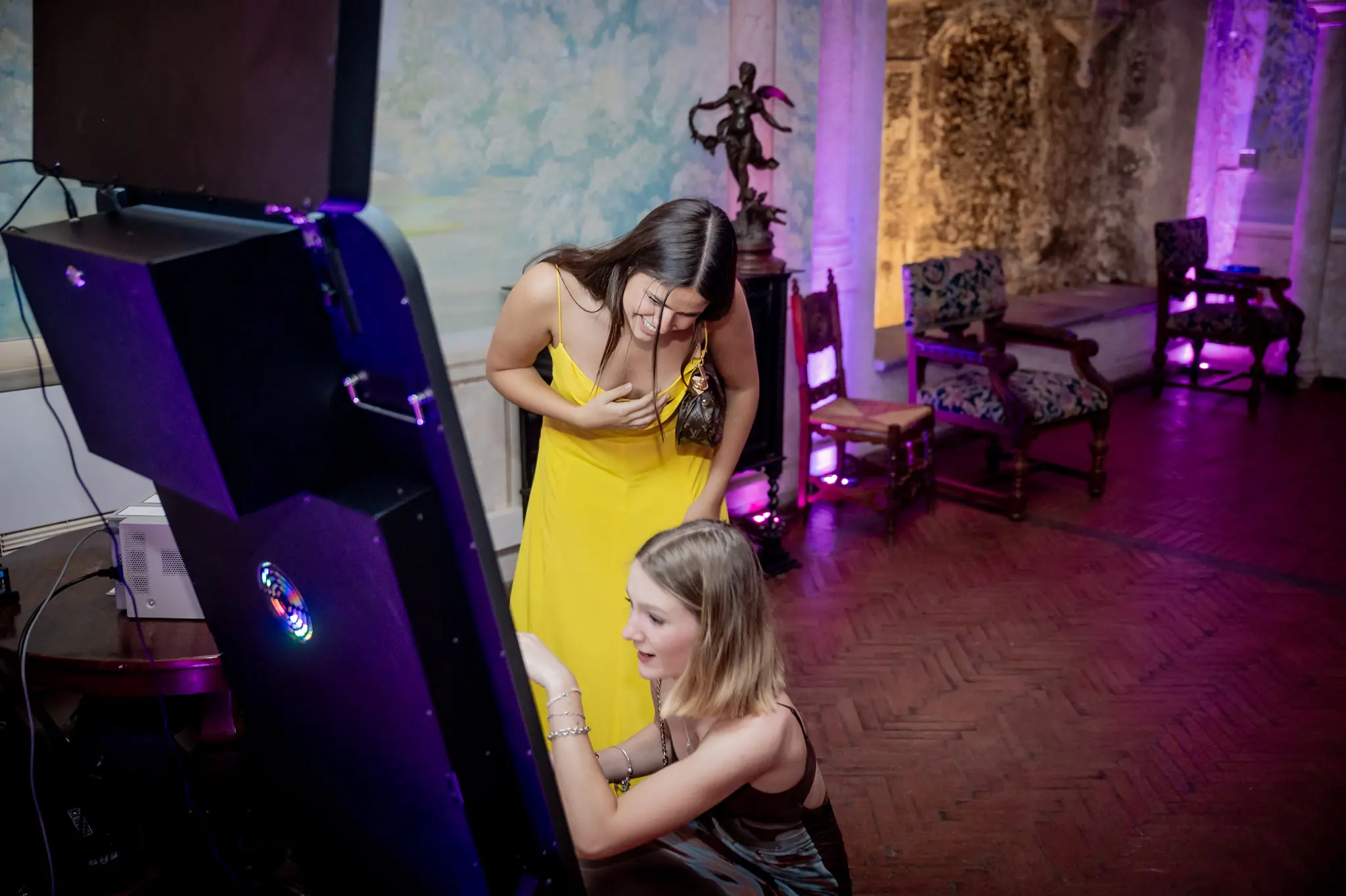 Photobooth a specchio in una sala per feste, con due ragazze pronte per la foto