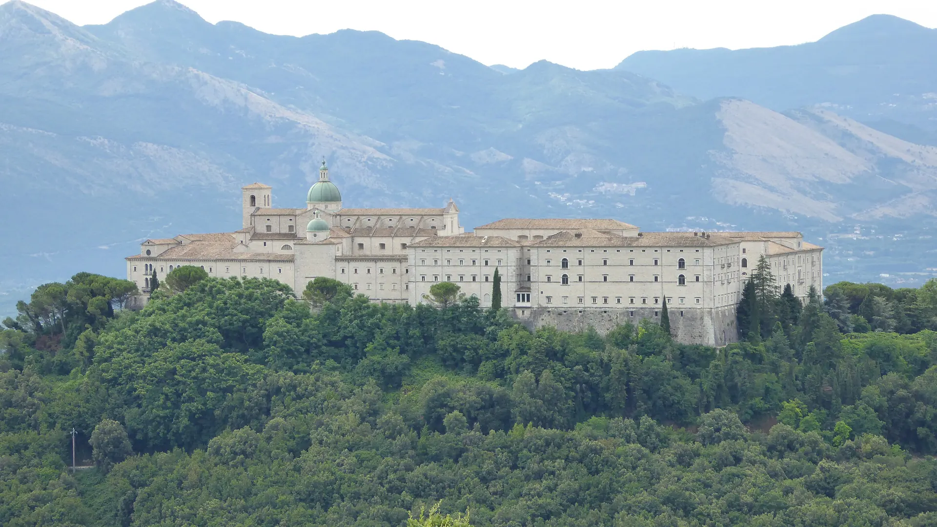 L’abbazia di Montecassino tra i boschi, con le montagne alle spalle